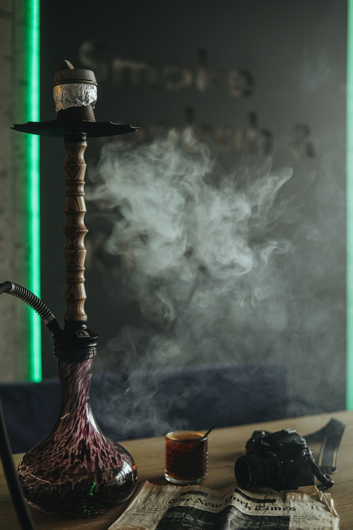 a smoking device with a cigarette and a glass of liquid
