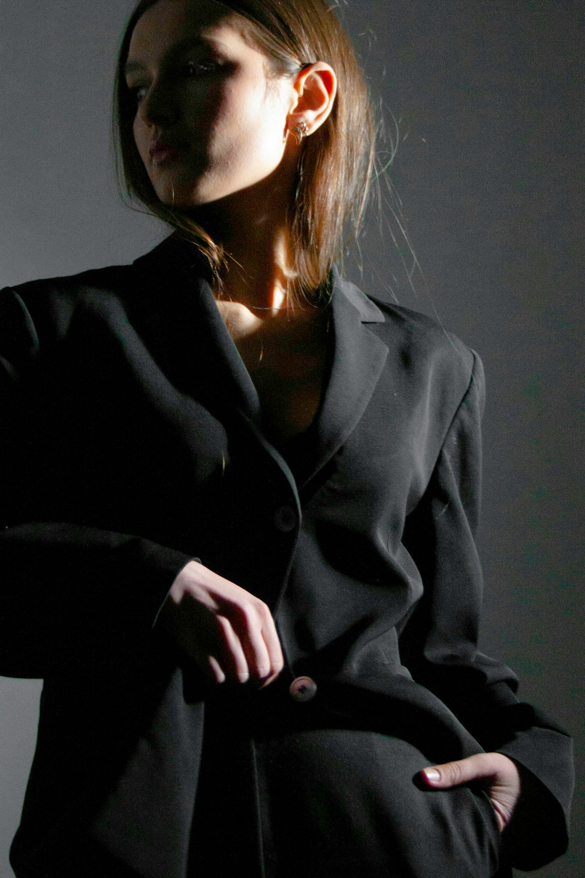 a woman in a black suit is posing for a picture