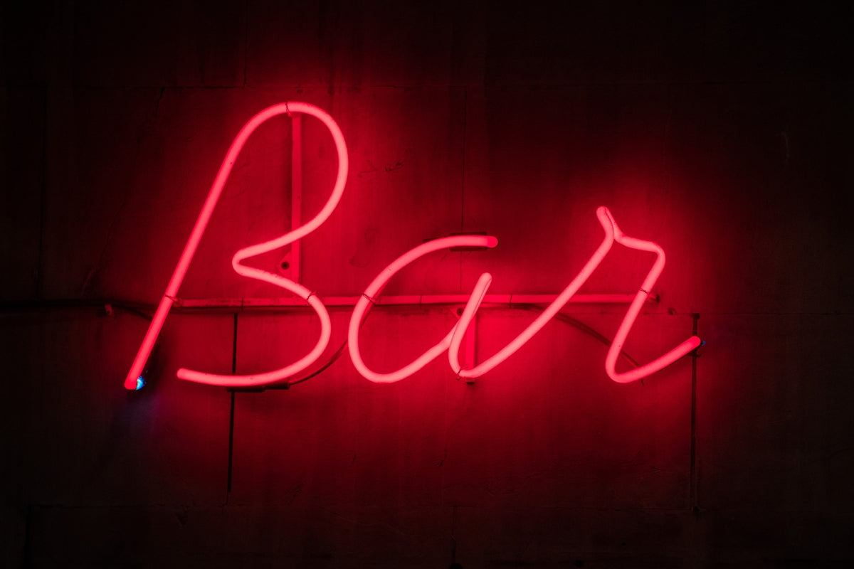 a neon sign that says bar on a wall