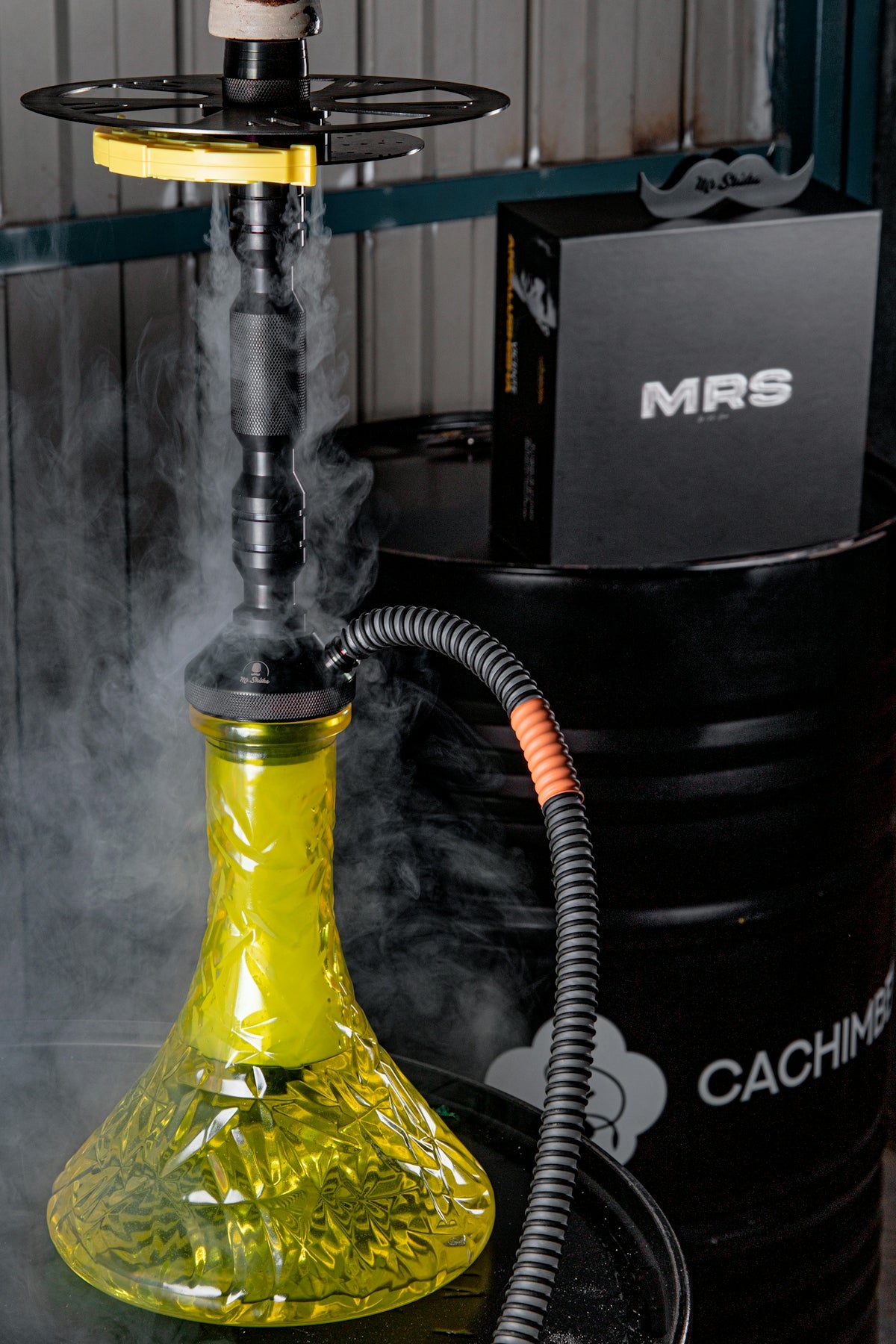 A yellow glass hookah sitting on top of a table
