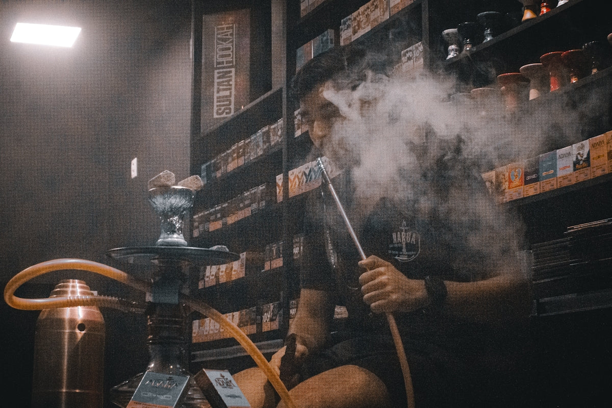 A man sitting in a room with a pipe in his hand