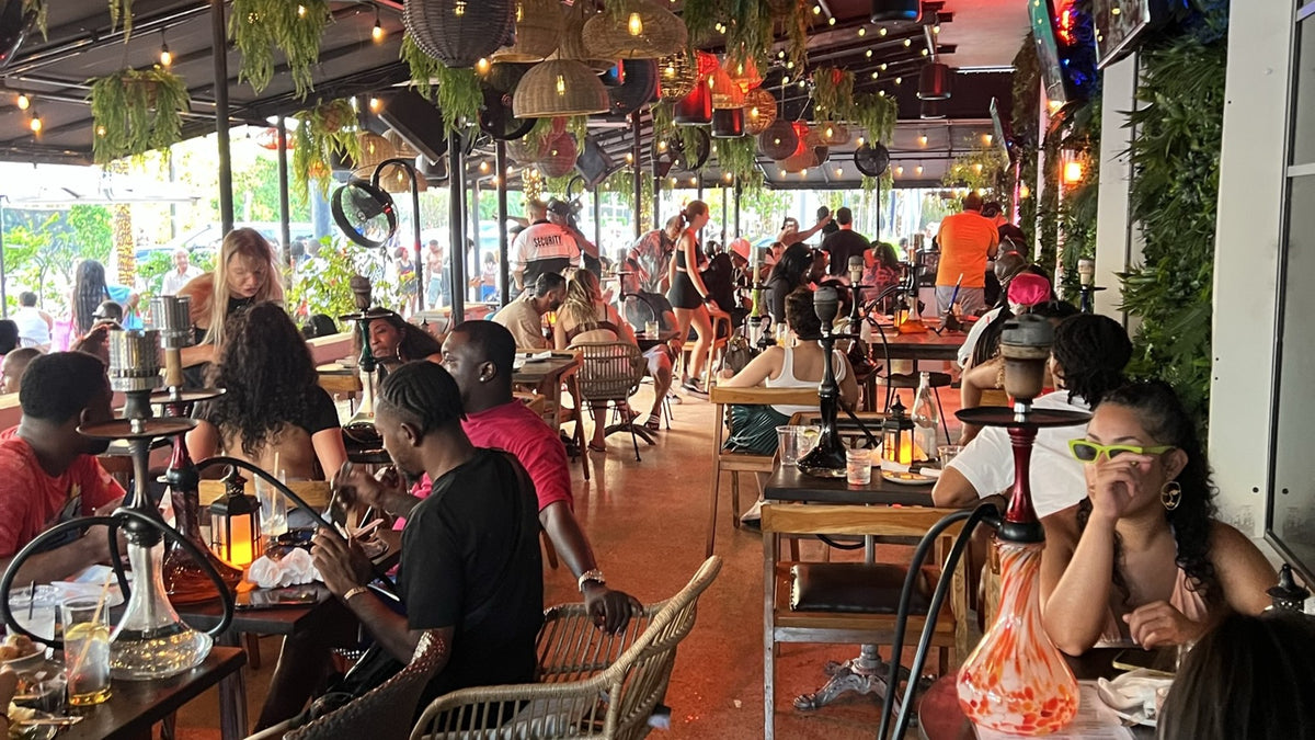 Hookah rental in Miami Beach — guests smoking hookahs on the porch at Wilde